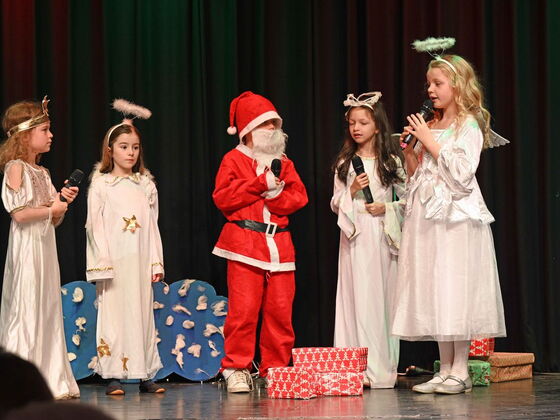 Kinder stehen als Engl und Nikolaus verkleidet auf der Bühne