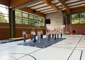 Schüler führen einen Tanz auf Sportmatten auf