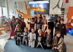 Gruppenfoto einer Schulklasse in gruseligen Halloweenkostümen