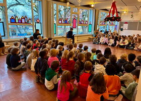 Schüler sitzen zusammen auf dem Boden
