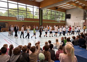 Die vierten Klassen marschieren in der Turnhalle im Kreis