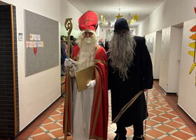 Nikolaus und Krampus stehen zusammen im Flur