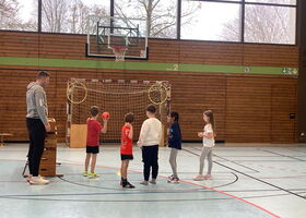 Ein Junge zielt mit einem Ball auf den Basketballkorb